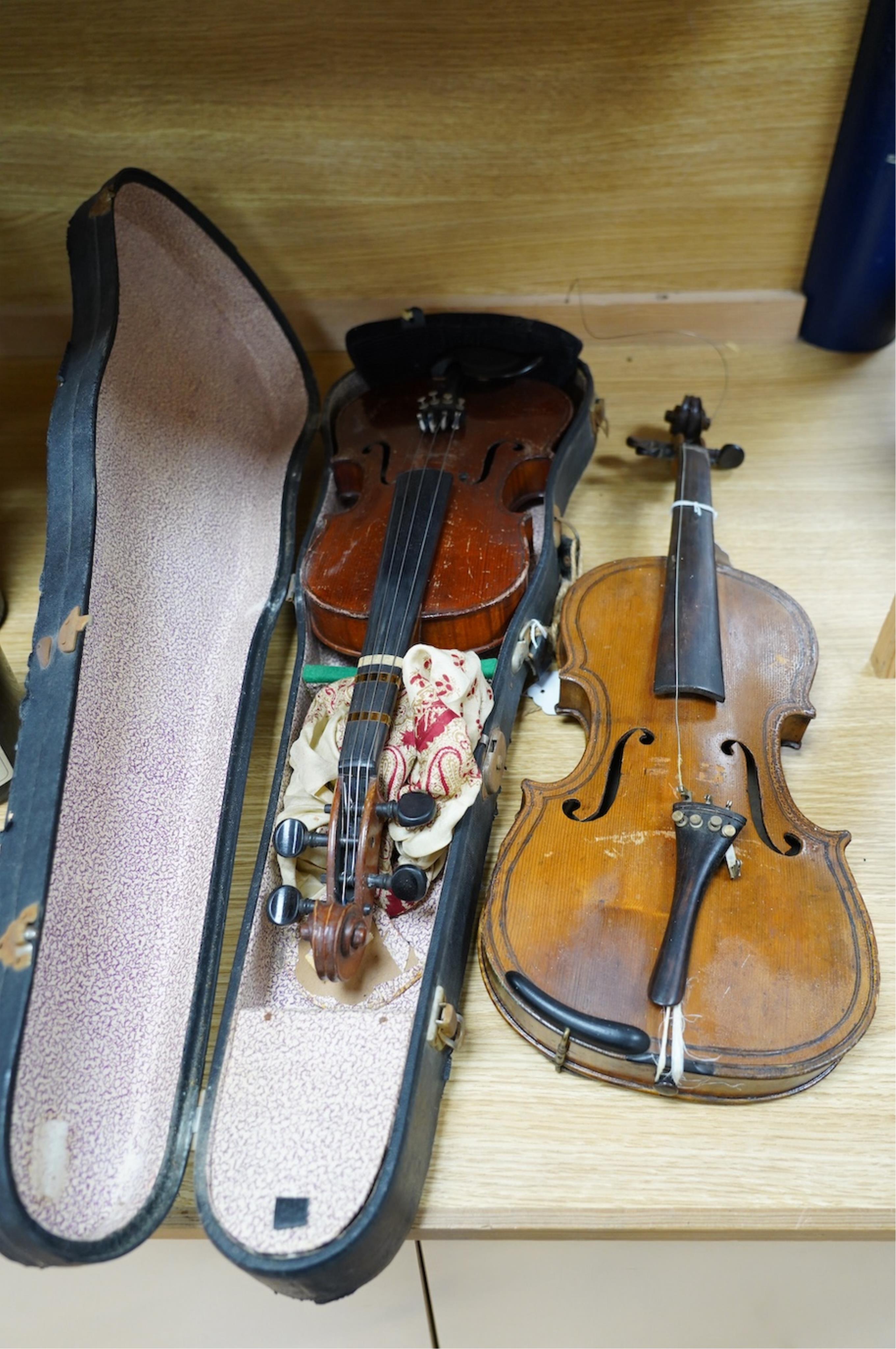 Two late 19th or early 20th century violins, one with case, back of largest measures 36cm. Condition - poor to fair